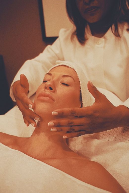 Massage sculptant du visage en institut : les mains de l'esthéticienne travaillent l'ovale